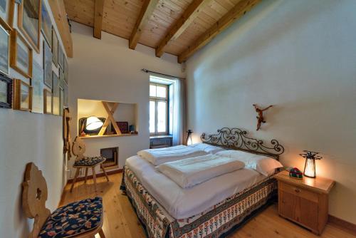 ein Schlafzimmer mit einem großen Bett und einer Holzdecke in der Unterkunft Chesa Roseg - Pontresina in Pontresina