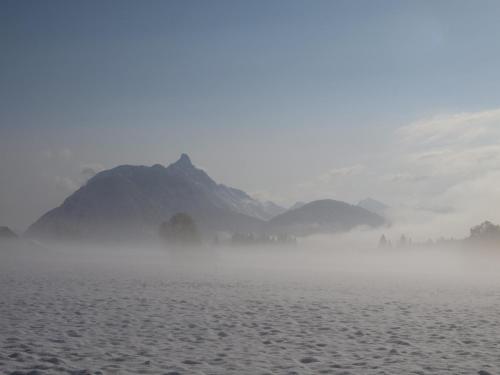 a foggy field with a mountain in the background at Alpenchalet im Leutaschtal in Leutasch