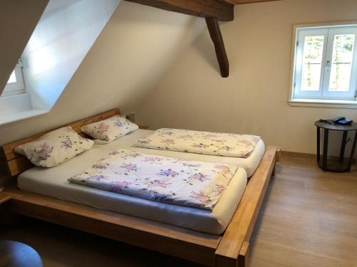 2 camas sentadas en una plataforma de madera en una habitación en Pension Untere Mühle, en Burghaun