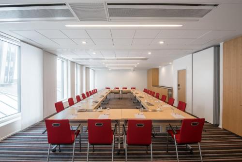 a large conference room with a long table and red chairs at Crowne Plaza Copenhagen Towers by IHG in Copenhagen