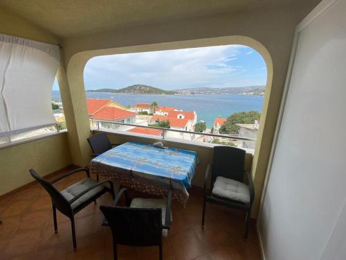 a balcony with a table and chairs and a view of the ocean at Apartments Viktor in Ražanj