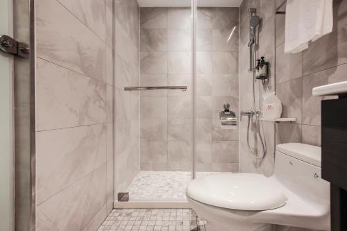 a bathroom with a shower with a toilet and a sink at Cityinn Hotel Taipei Station Branch I in Taipei