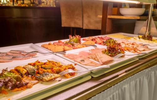 ein Buffet mit verschiedenen Speisen auf dem Tisch in der Unterkunft Ringhotel Warnemünder Hof in Warnemünde