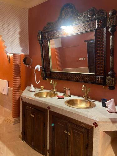 a bathroom with two sinks and a large mirror at LES JARDINS DE MARRAKECH in Marrakech