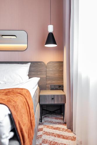a bedroom with a bed and a night stand next to a table at Kaunas in Kaunas