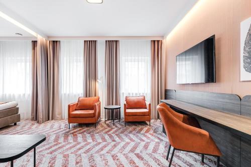 a hotel room with chairs and a flat screen tv at Kaunas in Kaunas