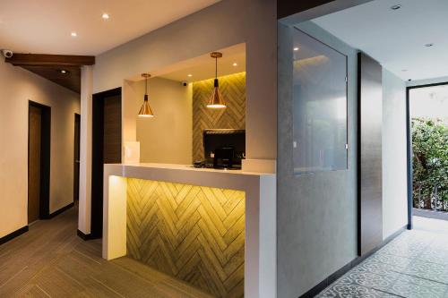 a lobby with a reception counter with a yellow wall at Hotel Marti in Mexico City