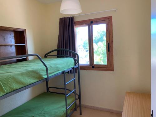 a room with two bunk beds and a window at Casa Mola in Perelló