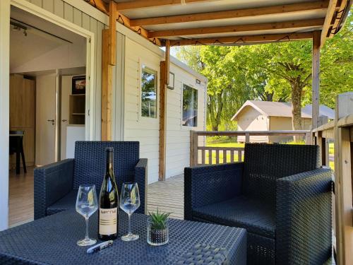 a bottle of wine sitting on a table with two glasses at Camping Ettelbruck in Ettelbruck