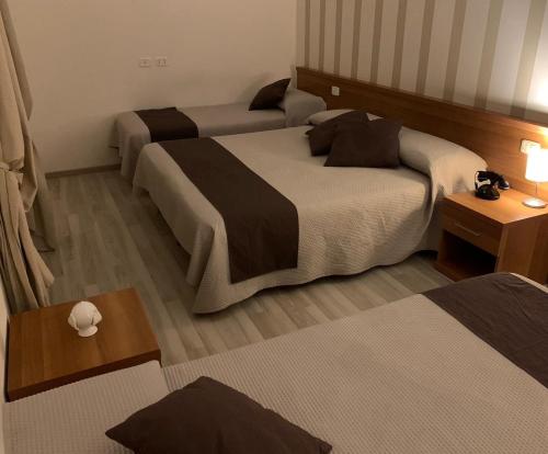 a hotel room with two beds and a table at Hotel Castel Miramonti in Selva di Fasano