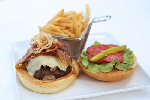 a white plate with a sandwich and french fries at Real Intercontinental Metrocentro Managua by IHG in Managua