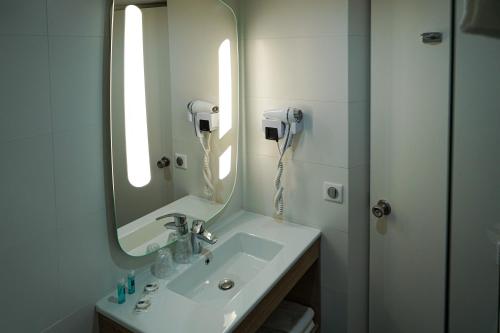 baño con lavabo con espejo y teléfono en ibis Styles Marseille Centre Prado Castellane en Marsella