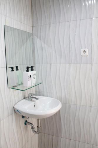 La salle de bains est pourvue d'un lavabo et d'un miroir. dans l'établissement bumimakhraja syariah 4, à Bandung