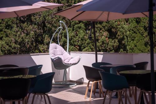 a patio with chairs and tables and umbrellas at Abaash Hotel Afon in Novy Afon