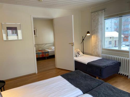 ロヴァニエミにあるホテル アーケヌス アパートメンツのベッド2台と窓が備わるホテルルームです。