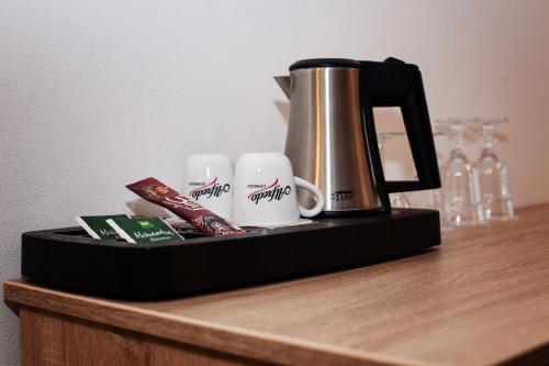 a tray with a coffee pot and cups on a counter at Penzion Dolíček in Cheb
