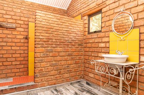 a bathroom with a sink in a brick wall at Otavi Vineyards Self-Catering & Camping in Otavi