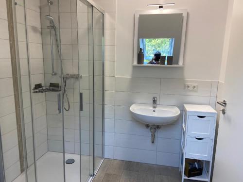 a bathroom with a glass shower and a sink at WG Ragöser Wasserrad in Sandkrug