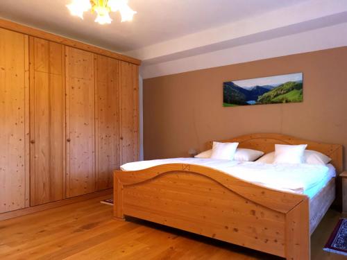 ルンツ・アム・ゼーにあるFerienwohnung Schlögelhoferのベッドルーム1室(木製ベッド1台付)