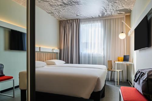 A bed or beds in a room at Ibis Montlhery Paris Sud