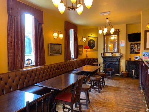a restaurant with tables and chairs and a bar at The Victoria in Newcastle under Lyme