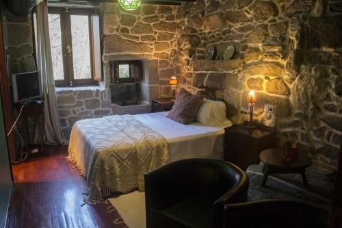 a bedroom with a bed and a fireplace at Pazo Larache in Santa Cristina de Cobres