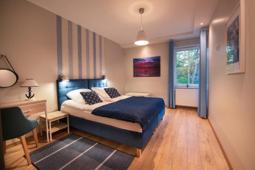 - une chambre avec un lit, un bureau et une fenêtre dans l'établissement Apartament MOUNTSEA Pobierowo , Grunwaldzka, à Pobierowo