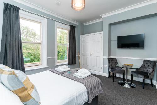 - une chambre avec un lit, un bureau et une télévision dans l'établissement St Mary's Apartments, à York