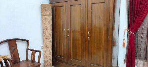 a wooden cabinet in a room with a red curtain at Penginapan Pendopo Kasih in Pugeran
