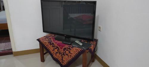a television sitting on a table with a remote control at Penginapan Pendopo Kasih in Pugeran