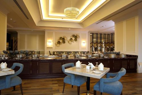 a restaurant with tables and chairs and a buffet at Vittori Palace Hotel and Residences in Riyadh
