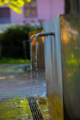 a pool of water coming out of a metal fence at Hotel Bank in Kiseljak