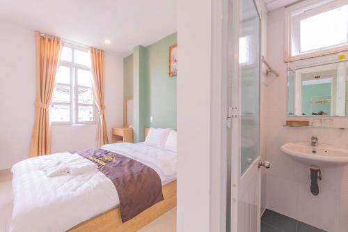 - une chambre avec un lit et un lavabo dans l'établissement Dalat Joy Hotel, à Đà Lạt