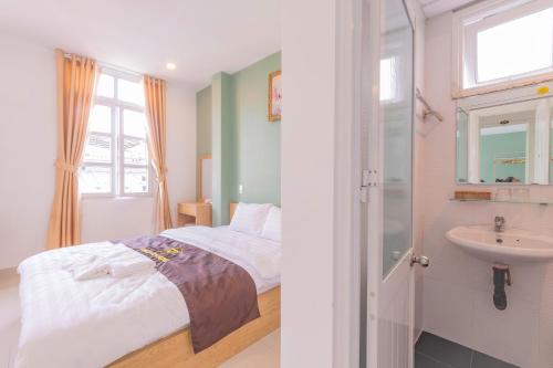 une chambre avec un lit et un lavabo dans l'établissement Dalat Joy Hotel, à Đà Lạt