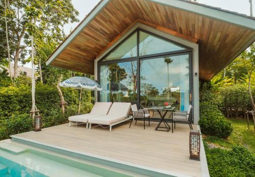 a house with a deck with a table and chairs at Island Escape Burasari in Phuket Town