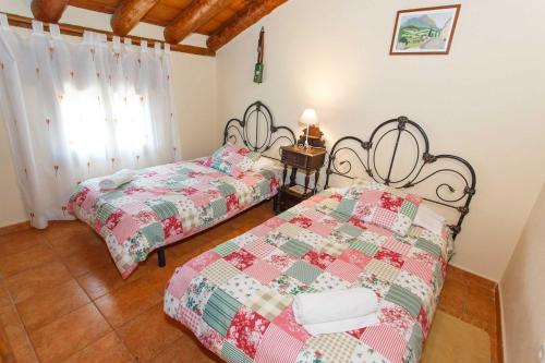 a bedroom with two beds and a window at El Bulín de Aldealengua in Ceguilla