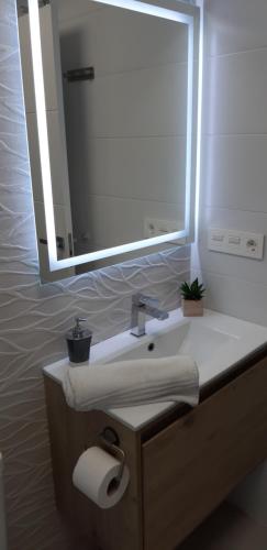 ein Badezimmer mit Waschbecken und großem Spiegel in der Unterkunft San Javier Sanuk Erjo new built apartment 2 bedrooms ground floor in Santiago de la Ribera