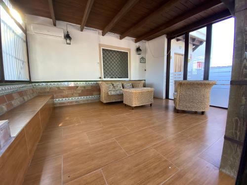 アンテケラにあるCasa Rural el Canalのウッドフロアの客室で、椅子と窓が備わります。