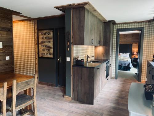 a kitchen with a sink and a table and a bed at Chalet Bull Zermatt in Zermatt