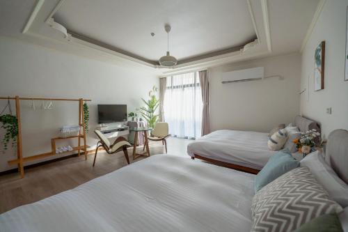 a hotel room with two beds and a desk at The Chambers in Tainan