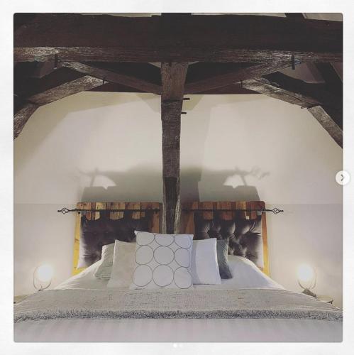 a bedroom with a bed with wooden beams on it at La Massonnière Gîte et chambres d'hôtes in Mondion