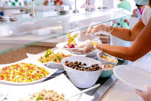 a buffet line with plates of food on display at Auramar Beach Resort in Albufeira