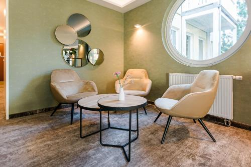 - un salon avec deux chaises, une table et un miroir dans l'établissement Familienhotel Villa Sano, à Baabe