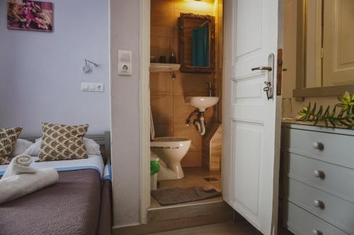 a small bathroom with a toilet and a sink at Aphrodite Art Hotel Aegina in Aegina Town