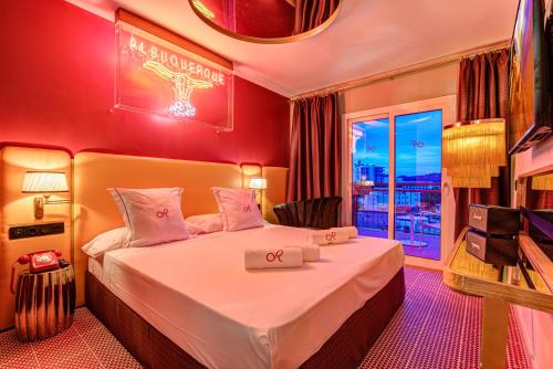 a hotel room with a bed and a television at Romeos Ibiza - Adults Only in San Antonio Bay