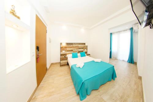 sypialnia z dużym łóżkiem i niebieskim kocem w obiekcie Hotel Zen Airport w mieście Torremolinos