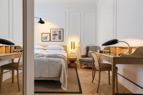 a bedroom with a bed and a desk and a chair at Heritage Hotel FERMAI MGallery Split in Split