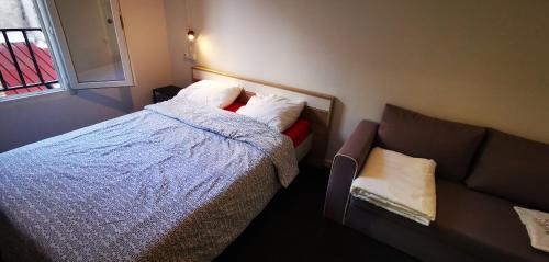 a small bedroom with a bed and a couch at Le Coffice Auberge de Jeunesse in Paris
