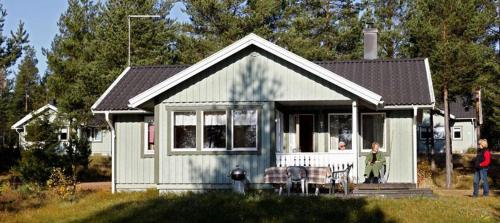 een klein huis met mensen die er buiten staan bij Marbyfjärden seaside village Lyckan in Eckerö