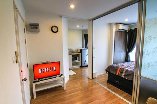 a living room with a television in a bedroom at Nice Condo near Ramkhamhaeng 60, Lam Sali MRT in Bangkok